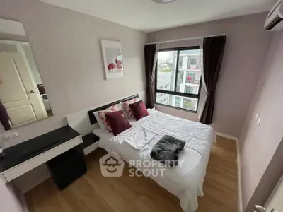 Cozy bedroom with modern decor and large window offering city views, perfect for urban living.