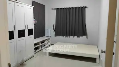 Minimalist bedroom with white wardrobe and platform bed, ideal for modern living.