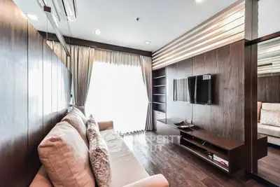 Modern living room with elegant wooden paneling and cozy sofa, featuring a wall-mounted TV and natural light.
