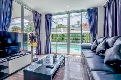 Modern living room with pool view, sleek furniture, and large windows for natural light.