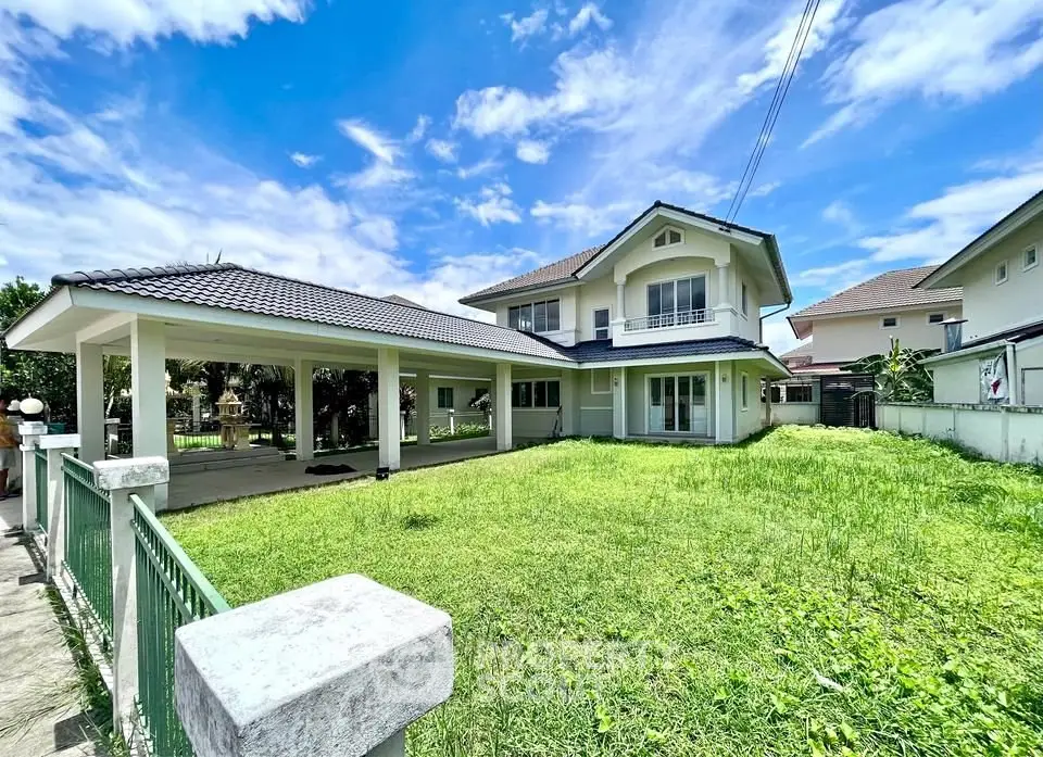 Spacious two-story house with lush green lawn and covered carport in a serene neighborhood.
