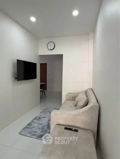 Modern living room with sleek design, featuring a wall-mounted TV and plush sofa for ultimate comfort.