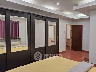 Spacious bedroom with mirrored wardrobe and modern lighting