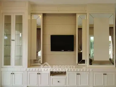 Elegant living room with built-in cabinets and wall-mounted TV