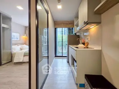 Modern apartment interior with sleek kitchen and cozy bedroom, featuring open layout and balcony view.