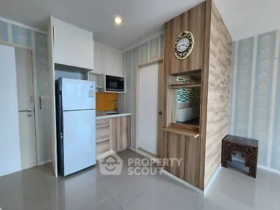 Modern kitchen with sleek appliances and stylish wood paneling in a cozy apartment.