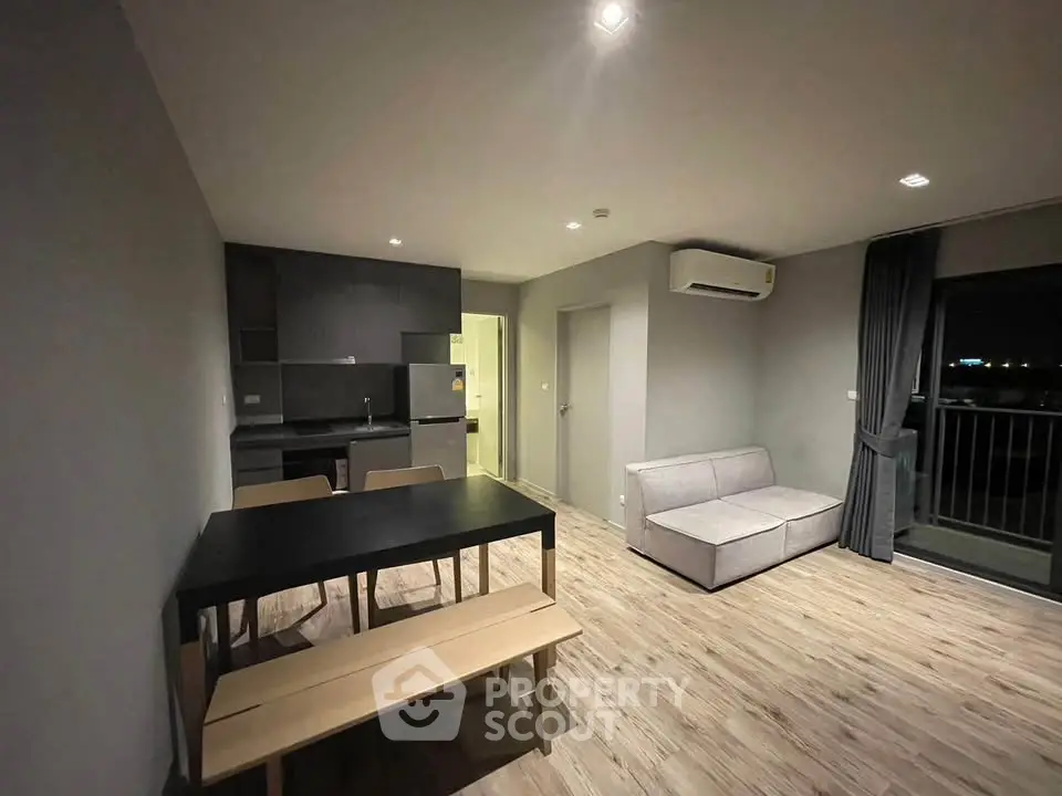 Modern open-plan living room with sleek kitchen and cozy seating area