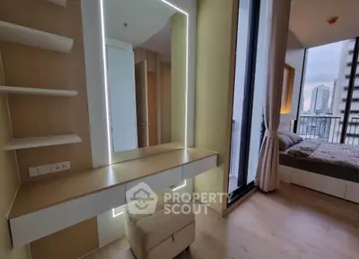Modern bedroom with floor-to-ceiling windows and city view, featuring a stylish vanity and cozy decor.