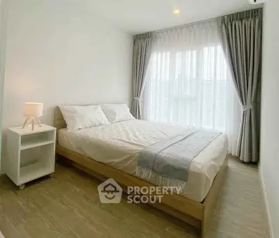 Bright and cozy bedroom with modern decor and large window for natural light.
