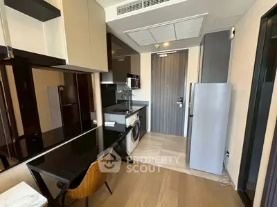 Modern kitchen with sleek appliances and stylish dining area in a compact layout.