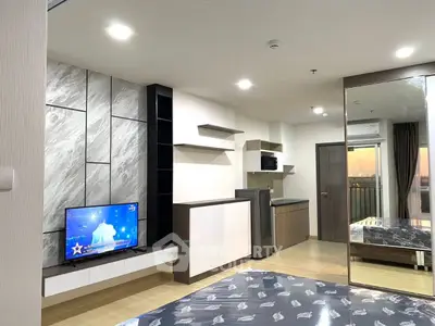 Modern studio apartment with sleek kitchen and stylish decor, featuring a cozy living area and balcony view.
