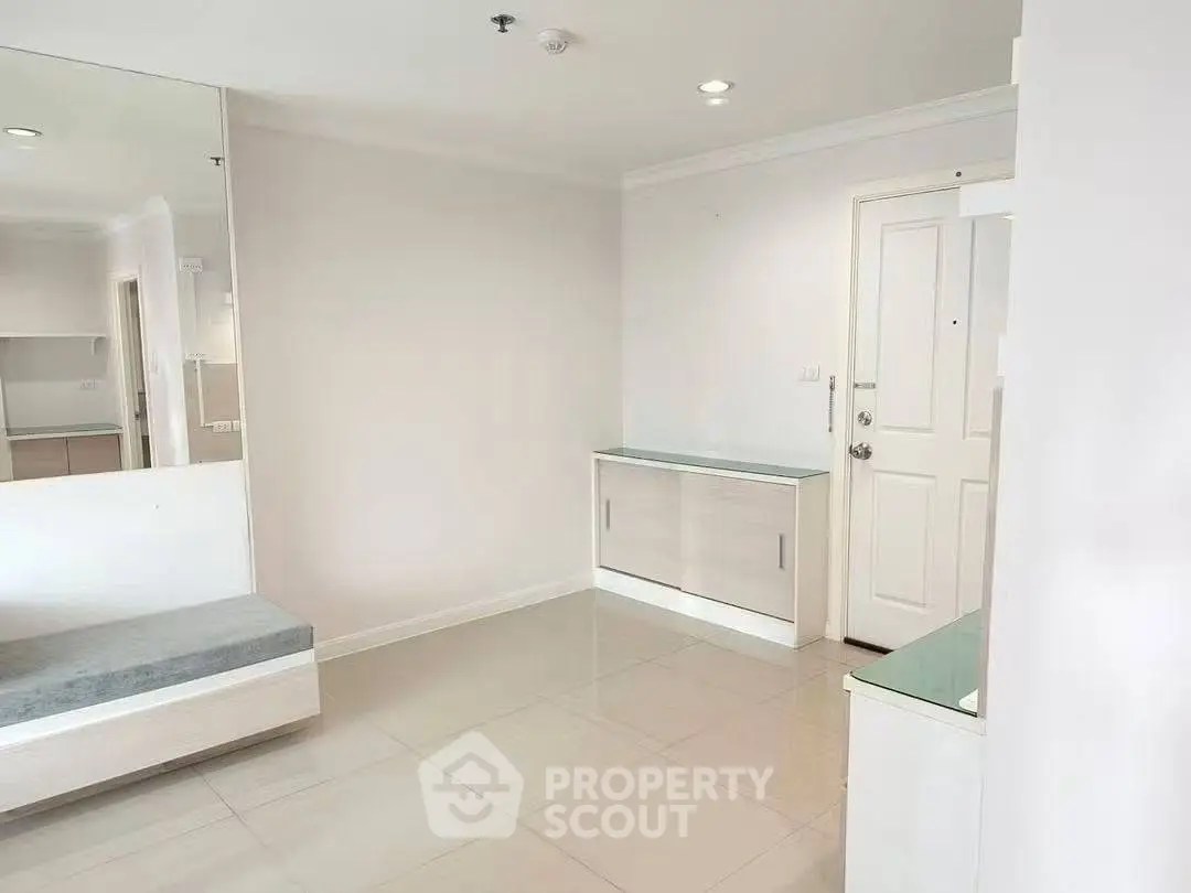 Spacious modern apartment entrance with sleek white interiors and built-in storage solutions.