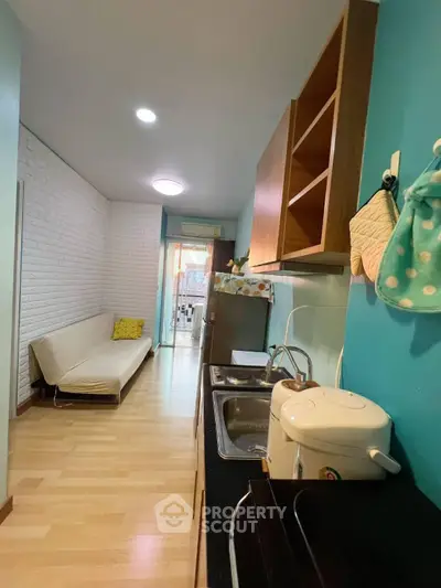 Charming kitchen with open layout and cozy living area, featuring modern appliances and stylish decor.