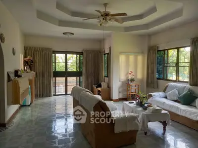 Spacious living room with cozy sofas and large windows offering natural light.
