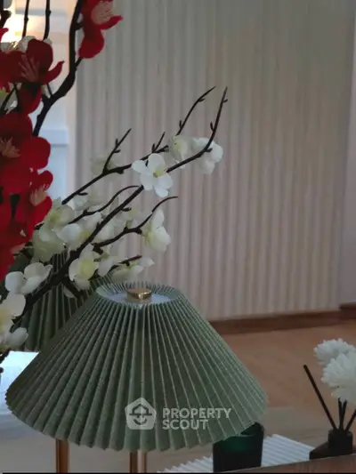 Elegant interior with stylish lamp and floral decor in modern living space.