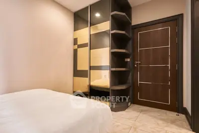 Modern bedroom with sleek mirrored wardrobe and stylish wooden door