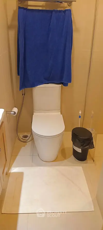 Compact bathroom with modern toilet and essential amenities.