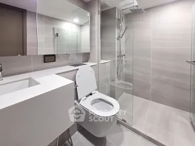 Modern bathroom with sleek design, featuring a glass shower and contemporary fixtures.