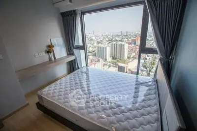 Modern bedroom with panoramic city view from large window, featuring sleek design and natural light.