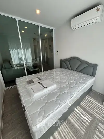 Modern bedroom with air conditioning and mirrored closet doors