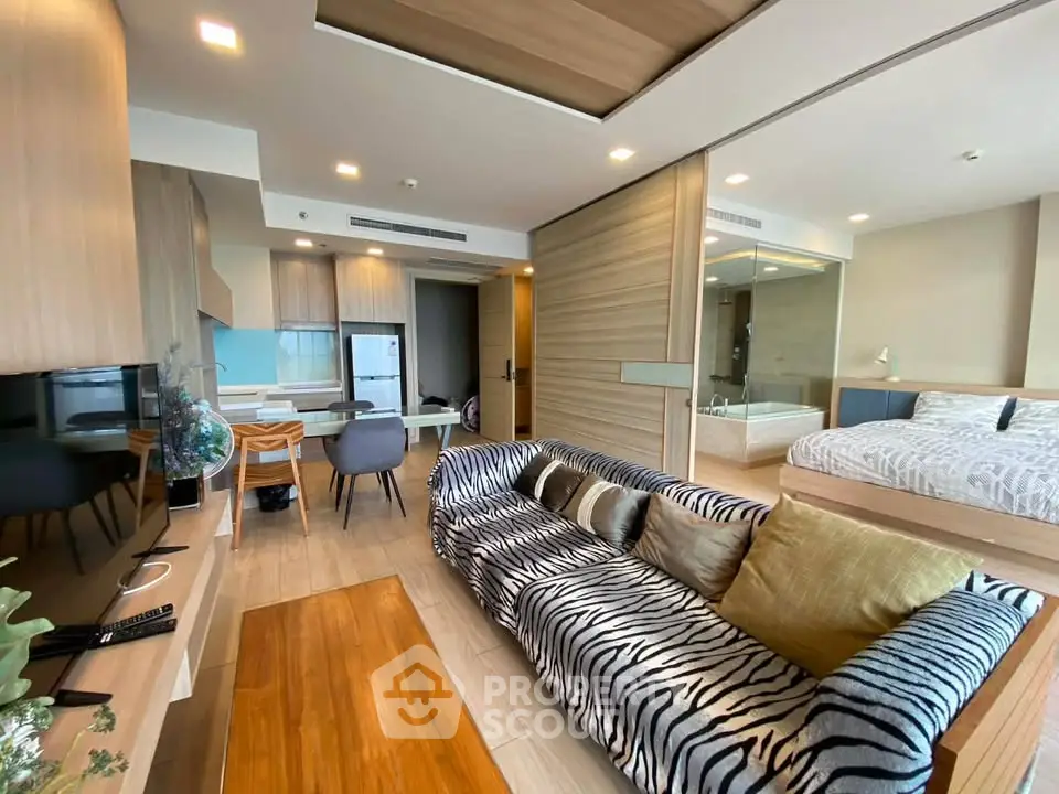 Stylish open-plan living room with zebra-patterned sofa and modern kitchen in a contemporary apartment.