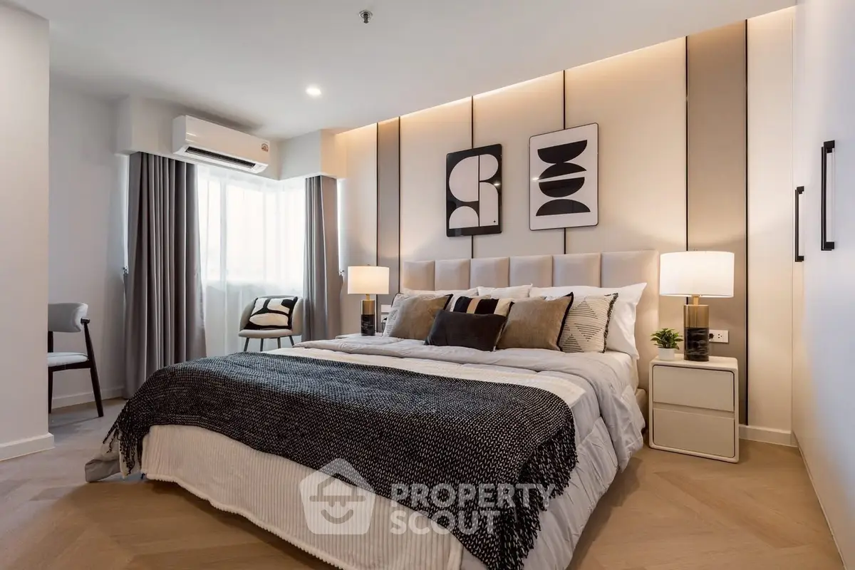Modern bedroom with stylish decor and cozy ambiance, featuring elegant lighting and contemporary artwork.