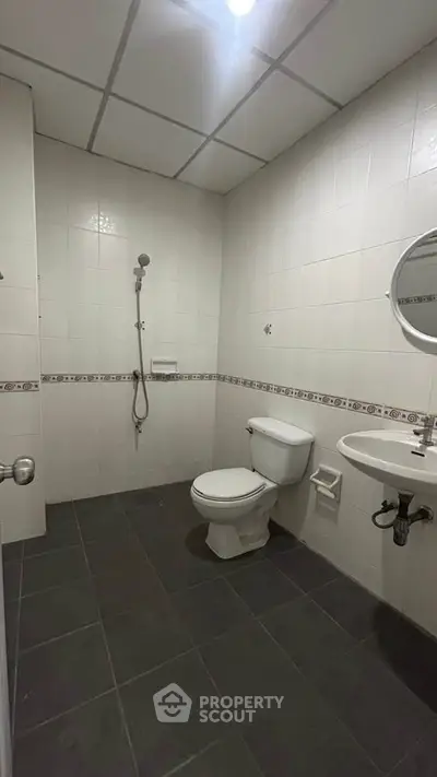 Spacious bathroom with modern fixtures and tiled flooring in a contemporary apartment.