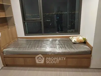 Cozy bedroom with city view, featuring a single bed and built-in storage, perfect for urban living.