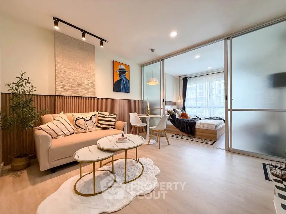 Modern open-plan living room with stylish decor and cozy bedroom view