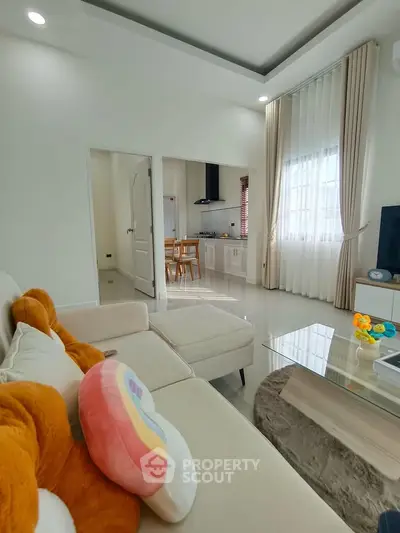 Modern living room with cozy sofa and open kitchen layout, perfect for family gatherings.