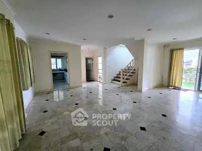 Spacious living room with marble flooring and natural light