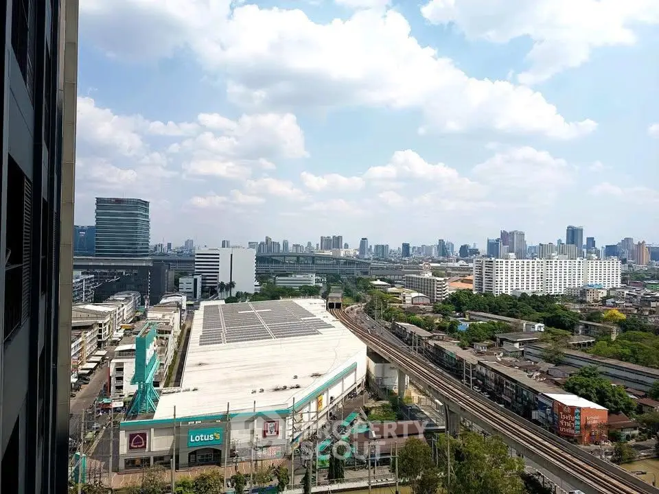 Stunning cityscape view from high-rise building showcasing urban skyline and railway tracks.