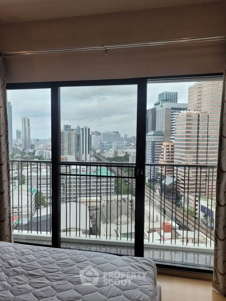 Stunning city view from a modern bedroom with large windows and balcony access.