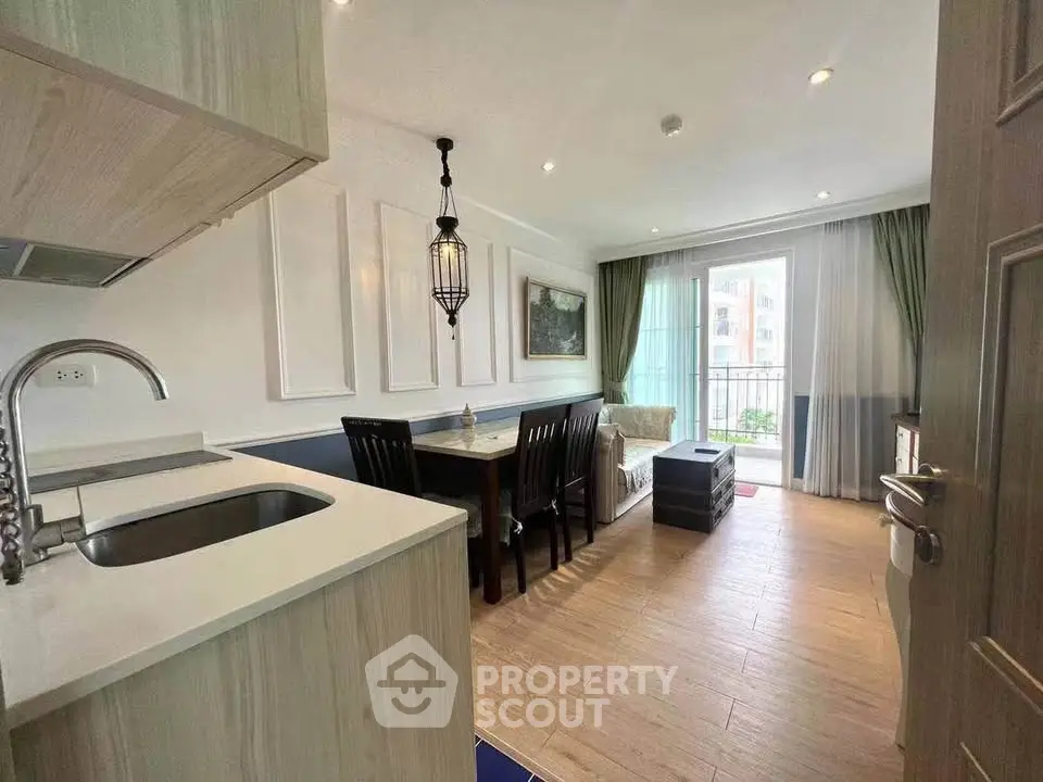 Modern open-layout kitchen and living room with elegant decor and natural light.