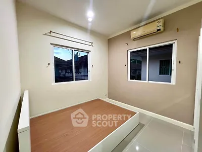 Spacious bedroom with large windows and air conditioning in modern home.