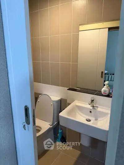 Compact modern bathroom with sleek fixtures and neutral tiles