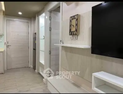Modern living room with stylish decor and wall-mounted TV in a cozy apartment.