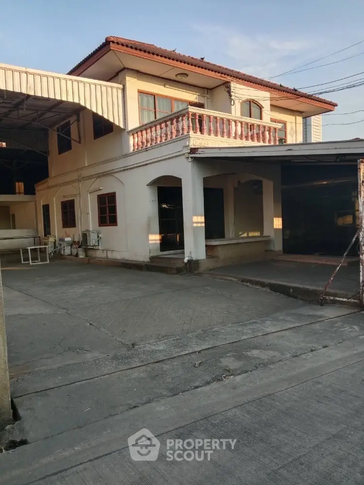 Spacious two-story house with balcony and ample parking space in a serene neighborhood.