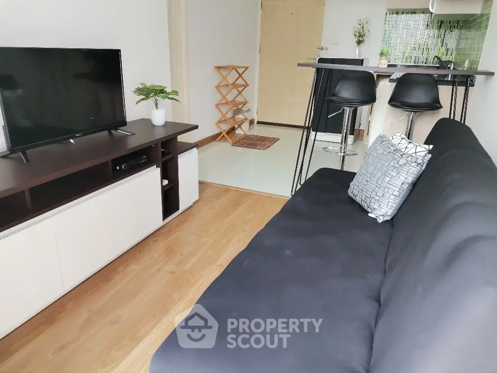 Modern living room with sleek black sofa and stylish TV unit