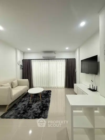 Modern living room with sleek furniture and large window for natural light.