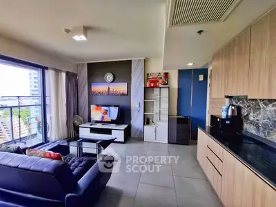 Modern living room with open kitchen, stylish decor, and city view balcony.