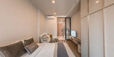 Modern bedroom with cozy seating area and sleek design in a stylish apartment.