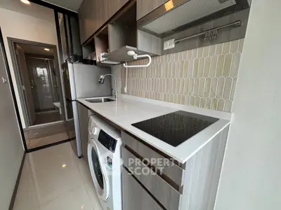 Modern kitchen with sleek cabinetry and built-in appliances in a compact layout.