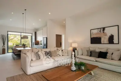 Spacious modern living room with elegant decor and open layout to dining area, featuring cozy sofas and stylish lighting.