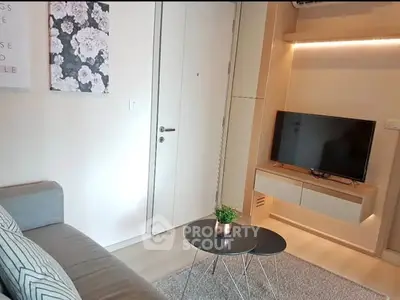 Modern living room with sleek furniture and wall-mounted TV in cozy apartment.