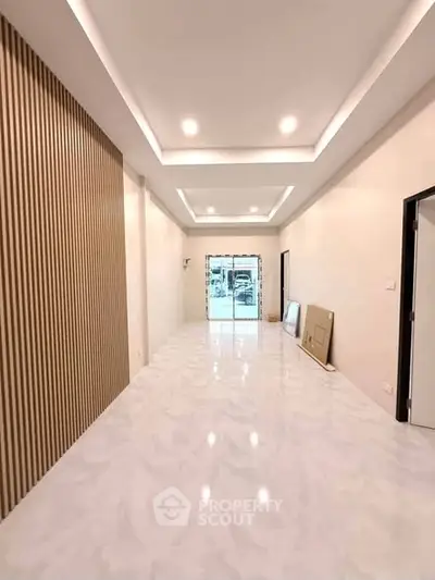 Spacious modern living room with sleek lighting and elegant flooring