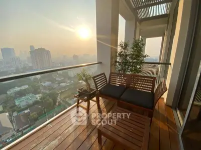 Stunning high-rise balcony with city skyline view and cozy seating area.