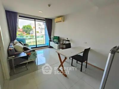Modern living room with balcony view, sleek furniture, and ample natural light in urban apartment.