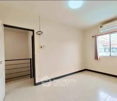 Bright empty room with window and air conditioning, ideal for customization.