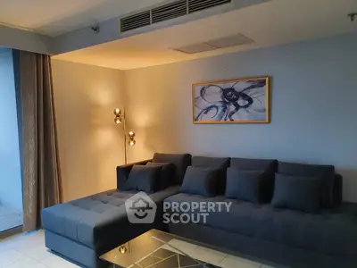 Modern living room with stylish gray sectional sofa and elegant lighting
